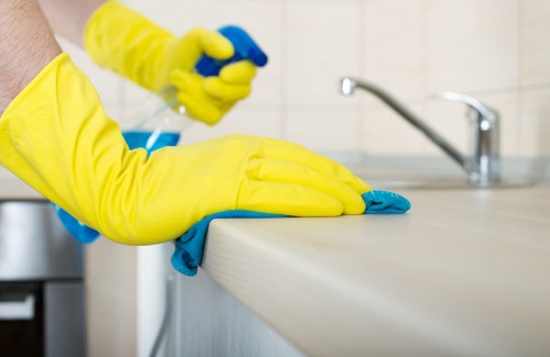 Cleaner wearing PPE while carrying out carpet cleaning